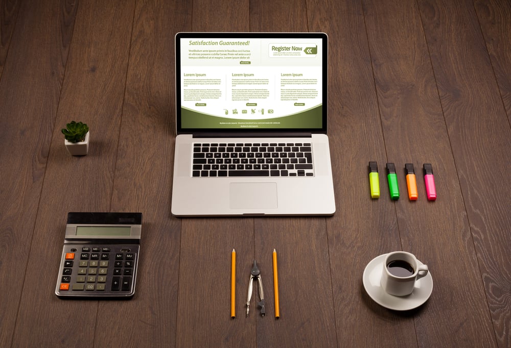 Workspace with a laptop computer, office accessories, and materials for an ecommerce website audit on a wooden table