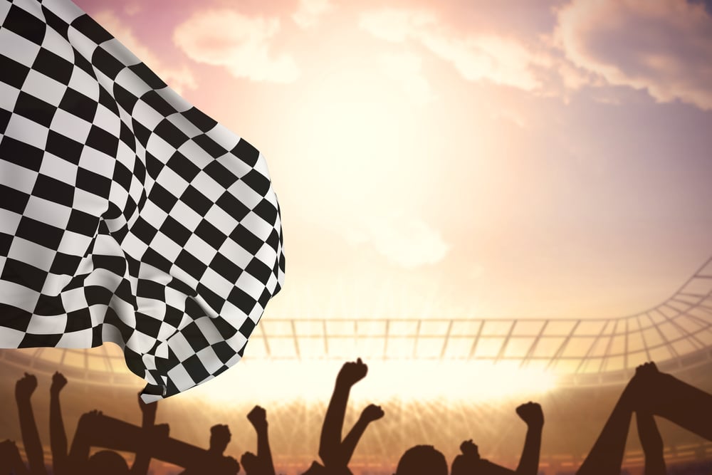 Checkered flag against football stadium with cheering crowd