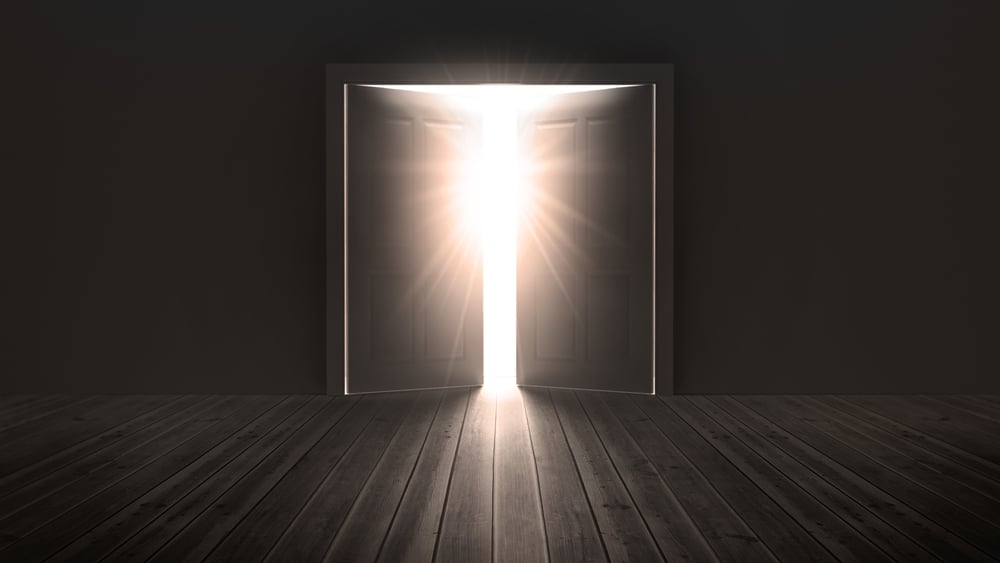 Doors opening to show a bright light in the darkness