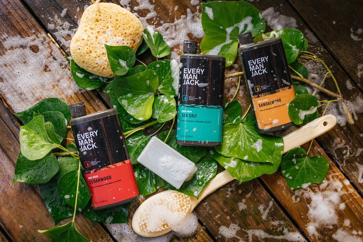 Three Every Man Jack body wash products with a sponge, sponge brush and soap